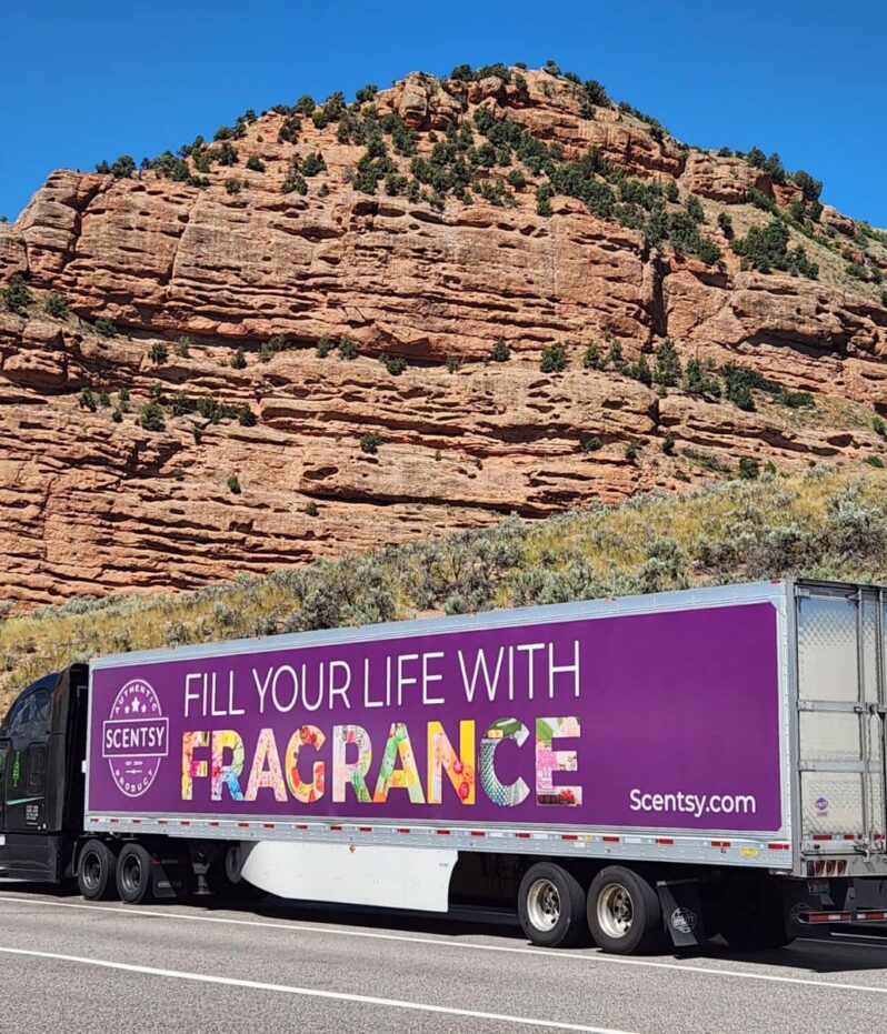 A black semi truck pulling a trailer in Echo Canyon, Utah